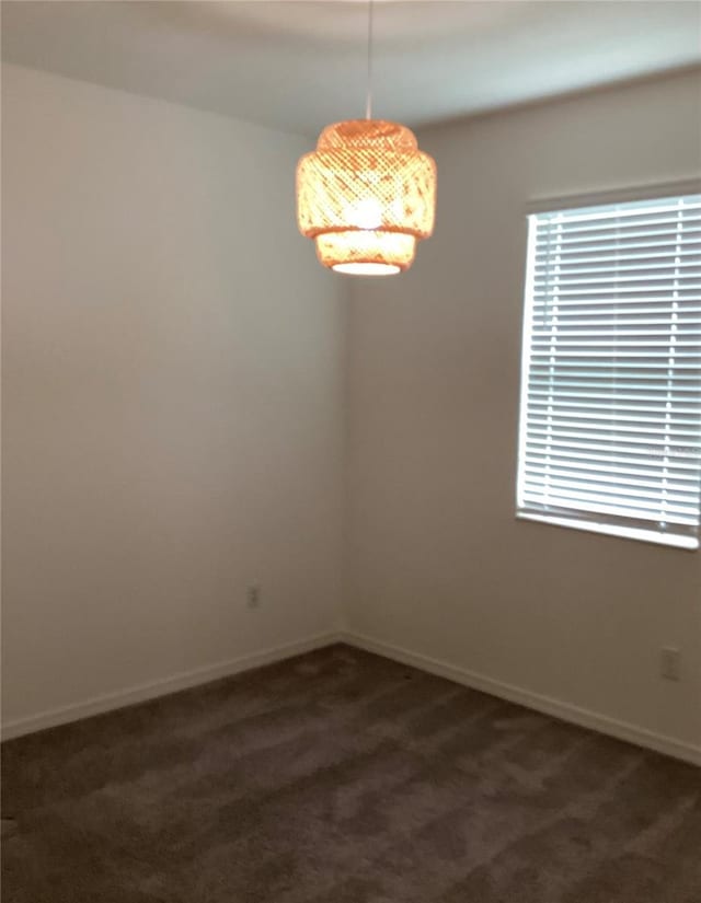 12630 Aston Dr, Hudson, FL 34669 - spare room featuring baseboards and dark carpet