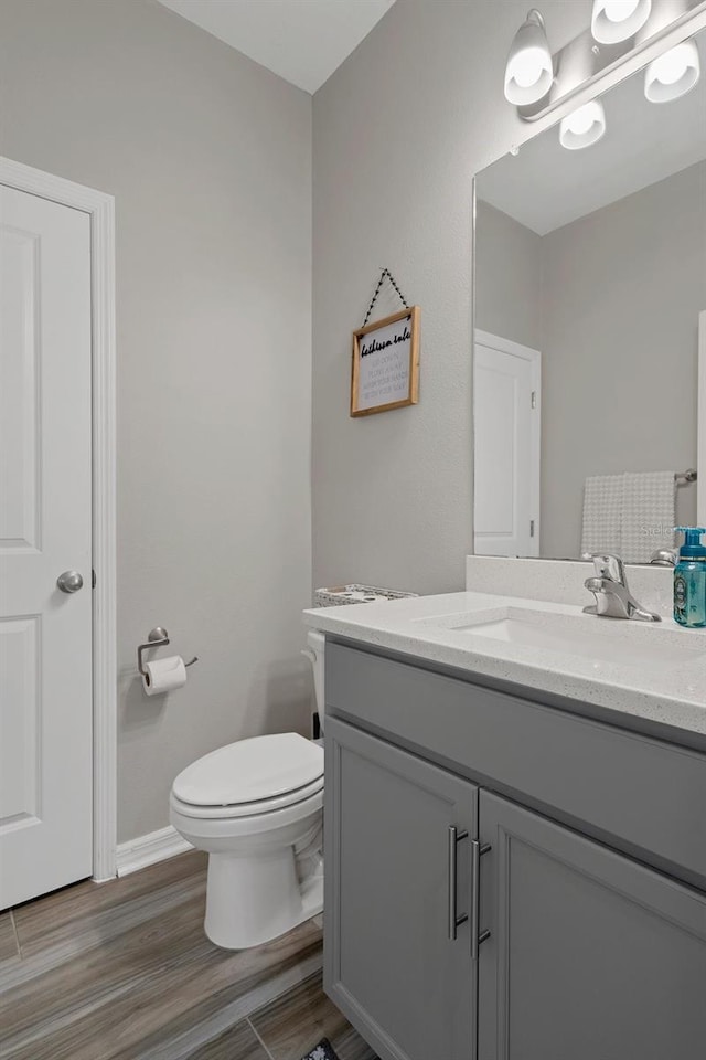 733 Old Windsor Way, Spring Hill, FL 34609 - half bathroom with toilet, baseboards, wood finished floors, and vanity