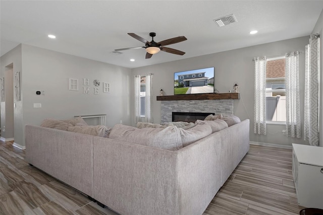 733 Old Windsor Way, Spring Hill, FL 34609 - living area featuring visible vents, baseboards, ceiling fan, and a stone fireplace
