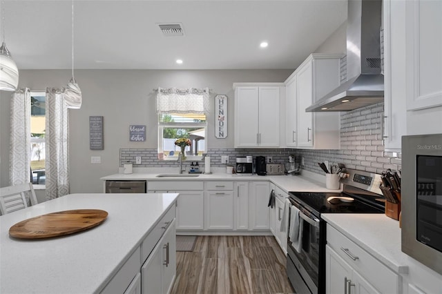 733 Old Windsor Way, Spring Hill, FL 34609 - kitchen with a sink, light countertops, wall chimney exhaust hood, stainless steel appliances, and visible vents