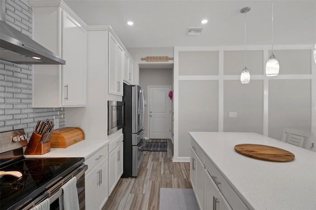 733 Old Windsor Way, Spring Hill, FL 34609 - kitchen with wall chimney range hood, white cabinets, appliances with stainless steel finishes, light countertops, and visible vents