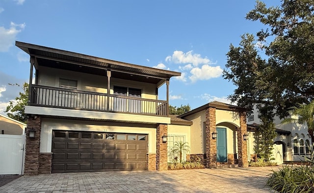 210 S Hale Ave, Tampa, FL 33609 - front of property featuring a balcony, stone siding, stucco siding, decorative driveway, and a garage
