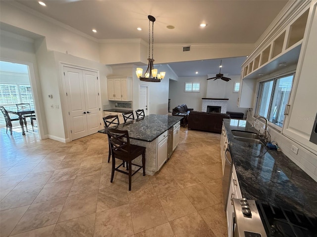 210 S Hale Ave, Tampa, FL 33609 - kitchen with a sink, a fireplace, a breakfast bar, open floor plan, and healthy amount of natural light