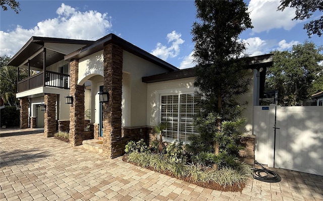 210 S Hale Ave, Tampa, FL 33609 - view of side of home with a balcony, stucco siding, and stone siding