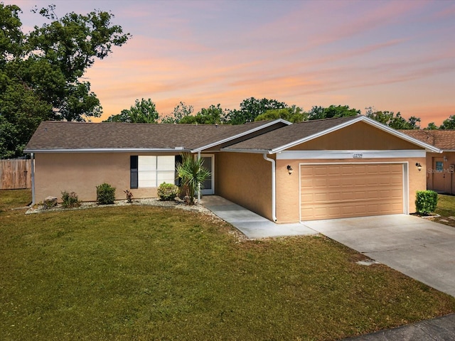 single story home with a garage, fence, a front yard, and concrete driveway