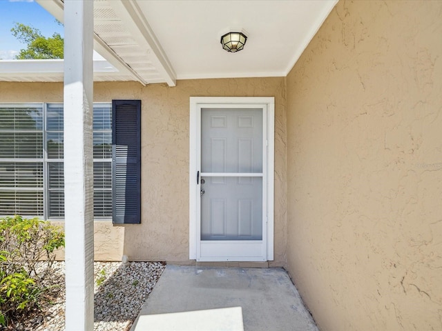 property entrance with stucco siding