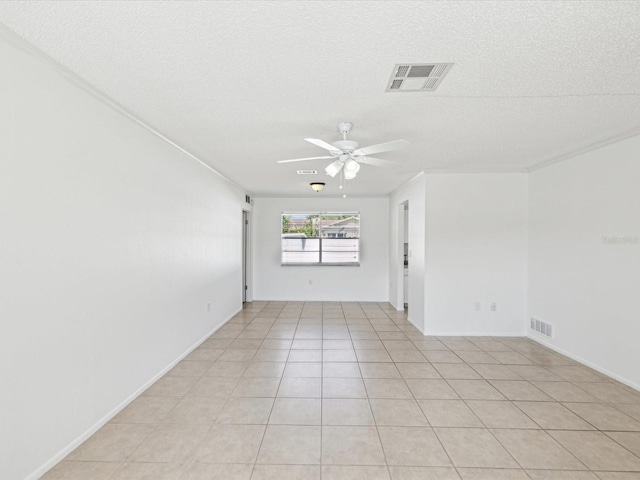 spare room featuring a textured ceiling, ceiling fan, visible vents, and light tile patterned floors