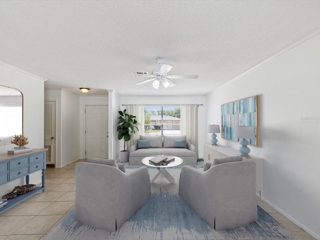 living room featuring a ceiling fan, a textured ceiling, visible vents, crown molding, and light tile patterned floors
