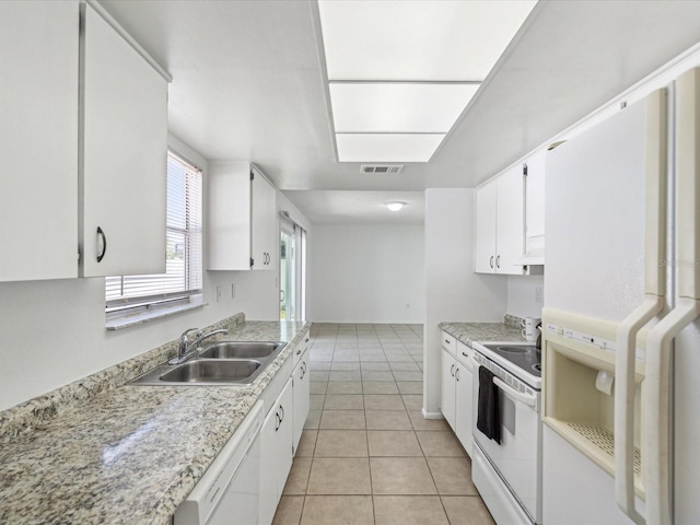 kitchen with light tile patterned flooring, a sink, white appliances, white cabinetry, and visible vents