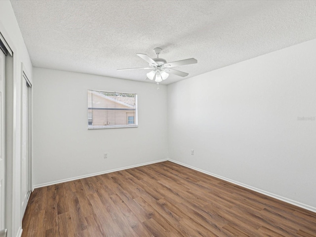 unfurnished bedroom with a ceiling fan, a textured ceiling, wood finished floors, baseboards, and a closet