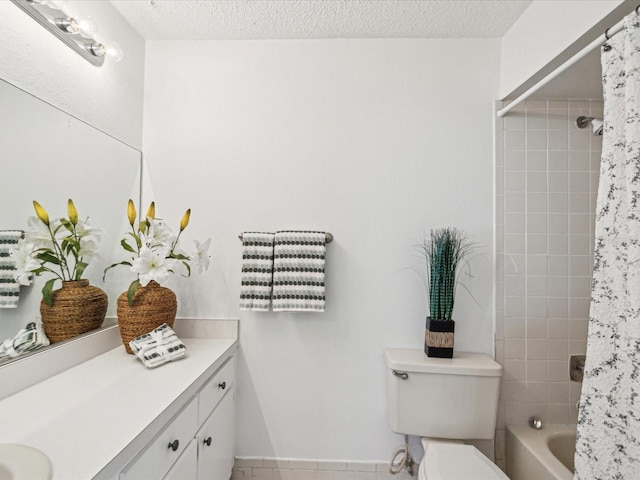 bathroom featuring vanity, shower / bath combo with shower curtain, toilet, and a textured ceiling
