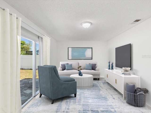 living room with a textured ceiling and visible vents