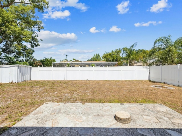 view of yard featuring a storage shed, an outdoor structure, a fenced backyard, and a patio area