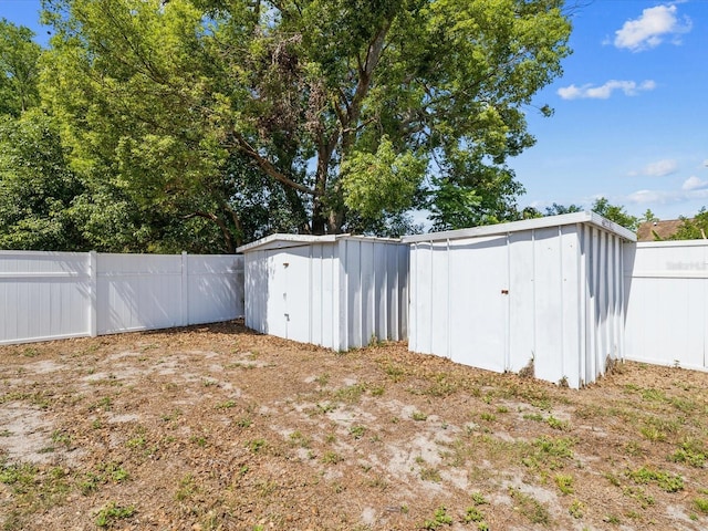view of yard with a storage unit, a fenced backyard, and an outdoor structure