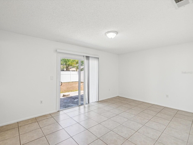 unfurnished room with baseboards, a textured ceiling, visible vents, and light tile patterned floors