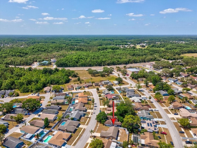 drone / aerial view featuring a residential view and a forest view