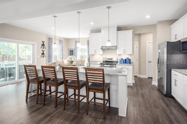 kitchen with a kitchen island with sink, a breakfast bar area, dark wood-type flooring, white cabinets, and appliances with stainless steel finishes