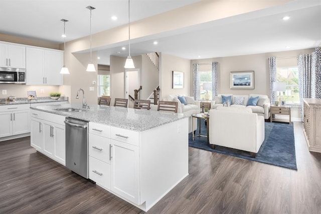 kitchen with a sink, appliances with stainless steel finishes, recessed lighting, and dark wood finished floors