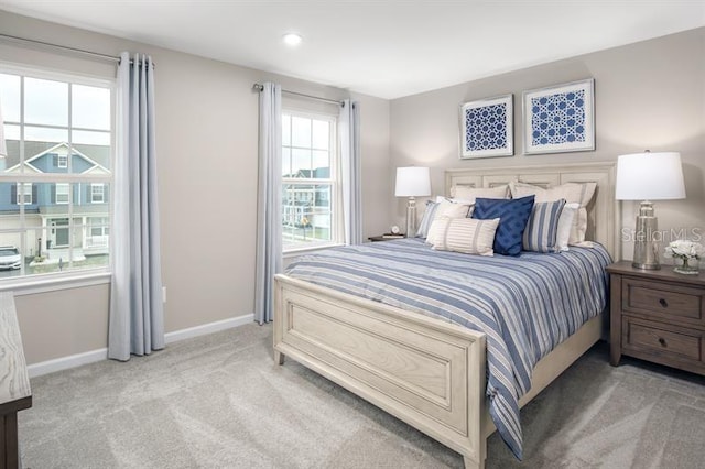 carpeted bedroom with baseboards and multiple windows