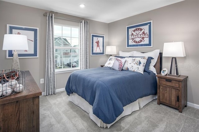 bedroom with baseboards and light colored carpet