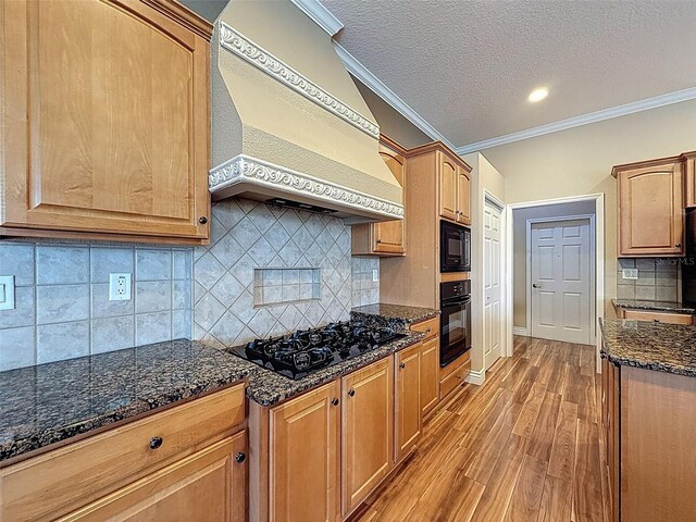 3464 Misty View Dr, Spring Hill, FL 34609 - kitchen featuring premium range hood, black appliances, light wood-type flooring, crown molding, and dark stone countertops