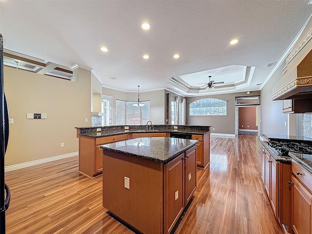 3464 Misty View Dr, Spring Hill, FL 34609 - kitchen with a center island, brown cabinetry, crown molding, light wood finished floors, and ceiling fan