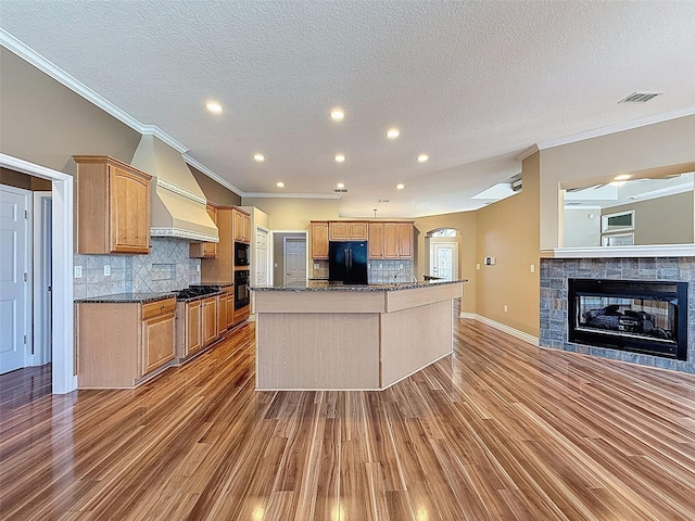 3464 Misty View Dr, Spring Hill, FL 34609 - kitchen with black appliances, ornamental molding, wood finished floors, a center island with sink, and tasteful backsplash