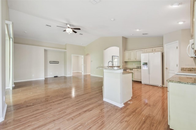 kitchen featuring ceiling fan, white appliances, arched walkways, open floor plan, and vaulted ceiling