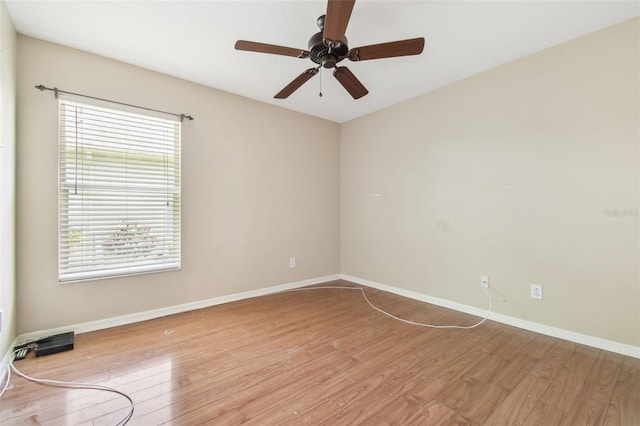 unfurnished room with a ceiling fan, baseboards, and light wood-style floors