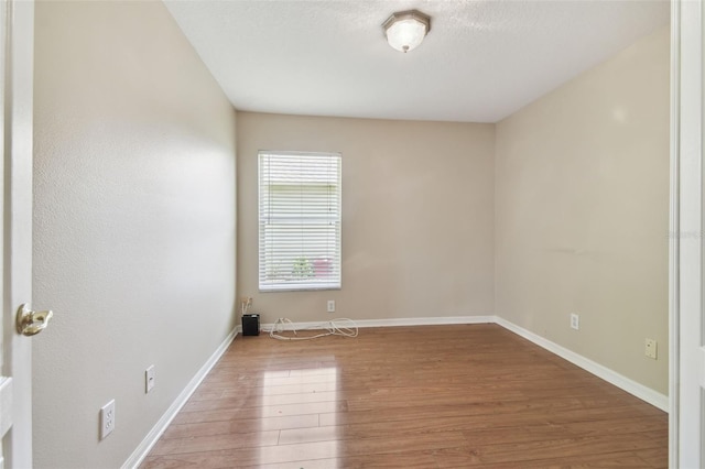 unfurnished room featuring baseboards and wood finished floors