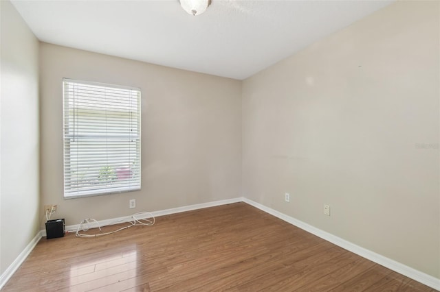 unfurnished room with baseboards and wood finished floors