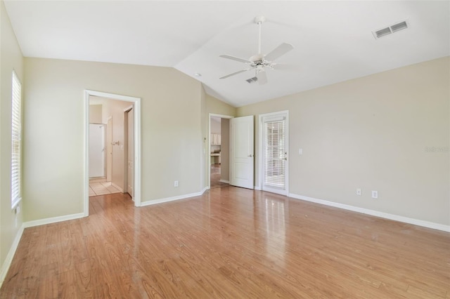unfurnished bedroom with visible vents, multiple windows, lofted ceiling, and light wood-type flooring