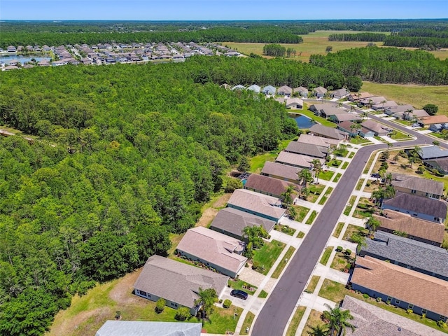 drone / aerial view featuring a residential view and a view of trees