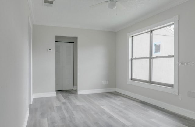 10859 William And Mary Ct, Orlando, FL 32821 - unfurnished room featuring crown molding, ceiling fan, light wood-style floors, baseboards, and visible vents