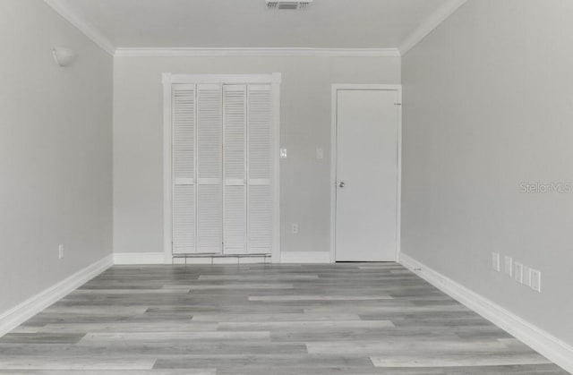 10859 William And Mary Ct, Orlando, FL 32821 - unfurnished bedroom featuring baseboards, ornamental molding, wood finished floors, and visible vents