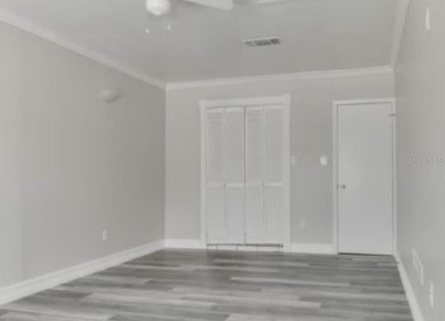 10859 William And Mary Ct, Orlando, FL 32821 - unfurnished room with crown molding, baseboards, and wood finished floors