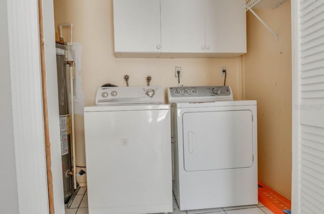 10859 William And Mary Ct, Orlando, FL 32821 - washroom with cabinet space, independent washer and dryer, light tile patterned floors, and gas water heater
