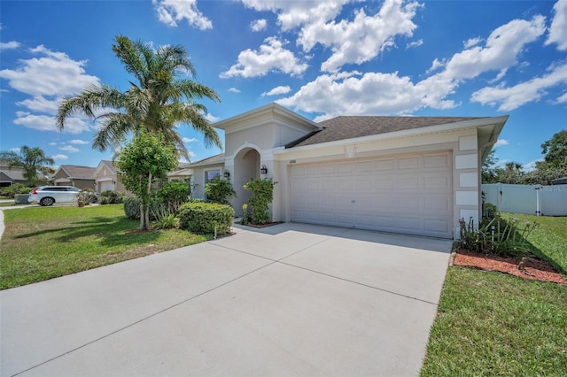 mediterranean / spanish-style house with fence, a front yard, stucco siding, concrete driveway, and an attached garage