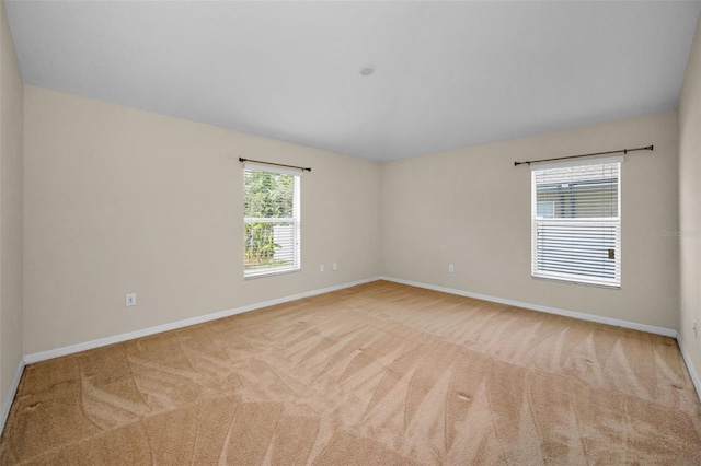 carpeted spare room featuring baseboards