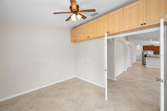 unfurnished room with baseboards, a ceiling fan, arched walkways, and visible vents