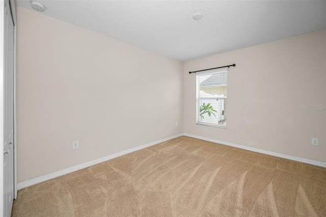 spare room featuring carpet floors and baseboards