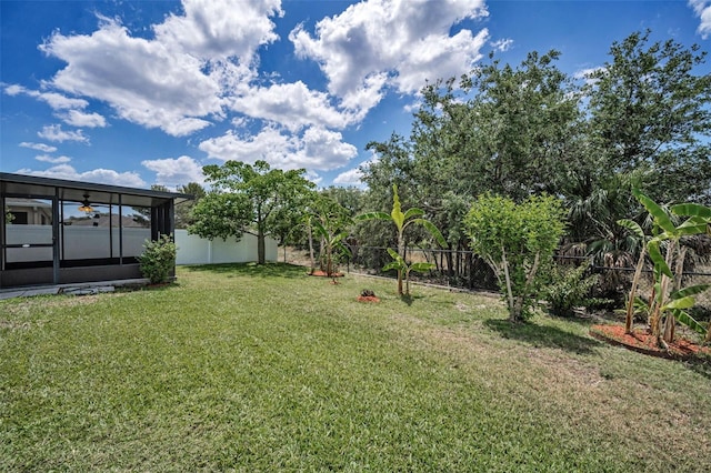 view of yard featuring a sunroom and a fenced backyard