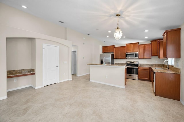 kitchen with appliances with stainless steel finishes, a sink, brown cabinetry, decorative light fixtures, and a kitchen island