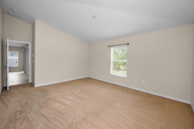 unfurnished bedroom with carpet flooring, baseboards, vaulted ceiling, and visible vents