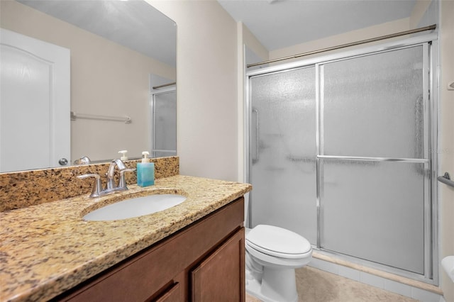 bathroom featuring vanity, tile patterned floors, toilet, and a shower stall