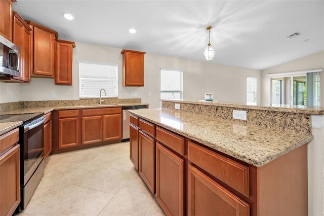 kitchen featuring light stone counters, appliances with stainless steel finishes, a sink, a center island, and visible vents