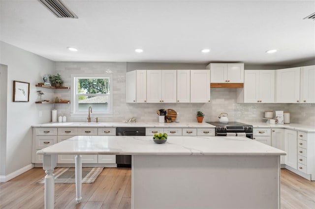 kitchen featuring a sink, decorative backsplash, dishwasher, and stainless steel range with electric cooktop