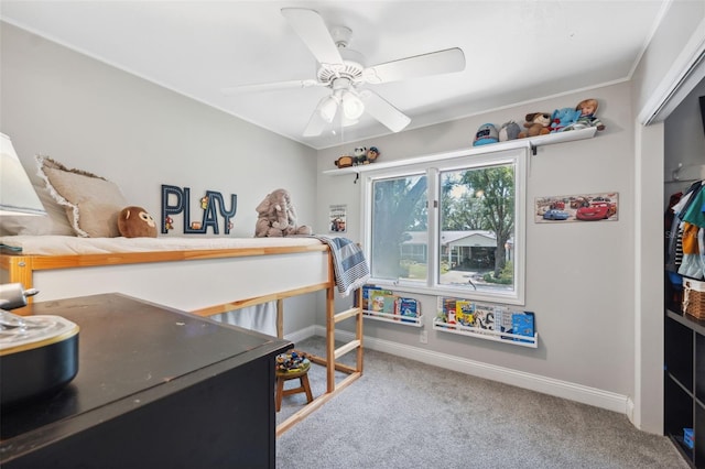 carpeted bedroom with a closet, baseboards, and a ceiling fan