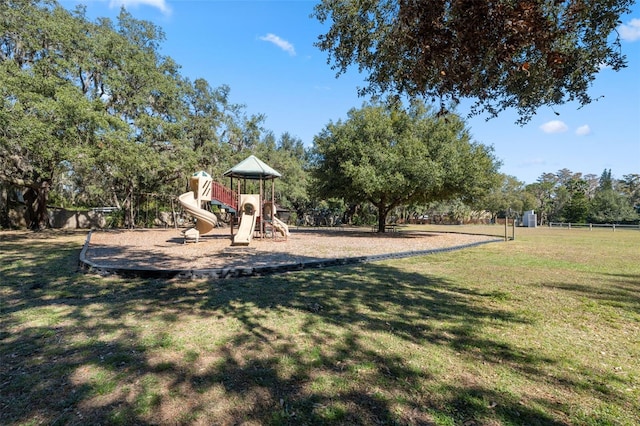 community playground featuring a lawn and fence