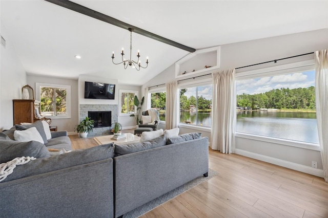 living area with a fireplace, baseboards, vaulted ceiling with beams, light wood finished floors, and a notable chandelier
